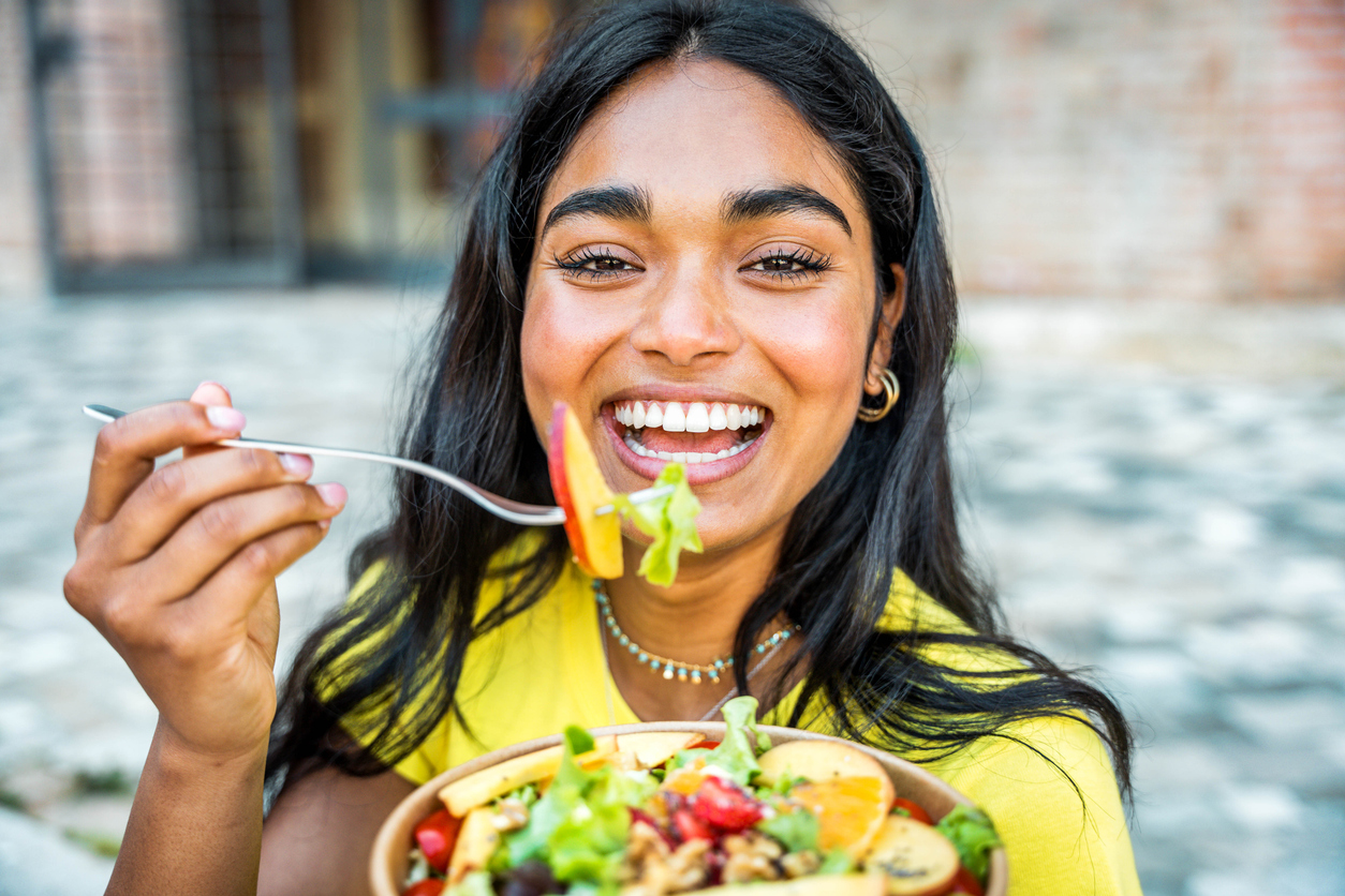 healthy smiling woman holds a salad 